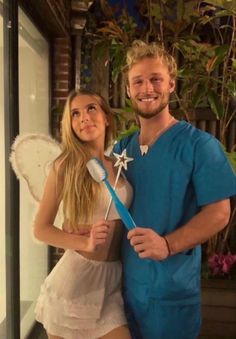 a man and woman dressed up in costumes posing for a photo with toothbrushes