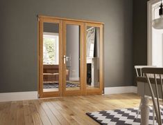 an empty room with wooden flooring and glass doors on the door to another room