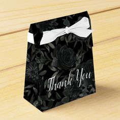 a black and white floral thank you bag with a bow on the front that says, thank you