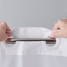 two hands holding onto a white shirt with metal bars on the front and back sides