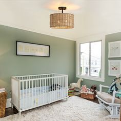 a baby's room with a white crib, rocking chair and large window