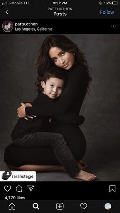 a woman holding a child in her arms and posing for an instagramr photo