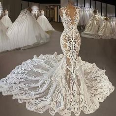 a white wedding gown on display in a room full of mannequins and dresses