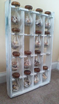 an old window is filled with seashells and sand in glass bottles that are hanging on the wall