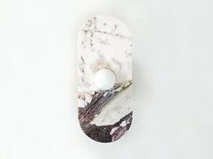 a marbled object with an egg on it's side, against a white background