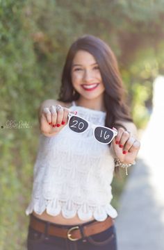 a woman holding up two black rocks with the word love written on them in front of her