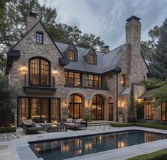 a large house with a pool in front of it and lots of windows on the side