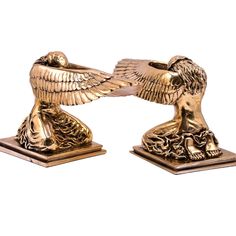 two golden eagle figurines sitting on top of each other