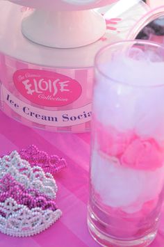 a pink table topped with a mixer and a glass filled with liquid