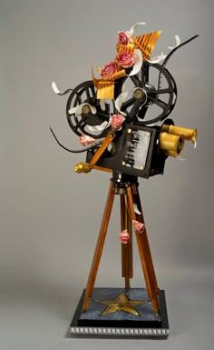 an old fashioned movie projector sitting on top of a wooden tripod with wheels