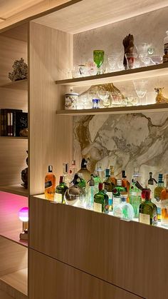 the shelves are filled with many different types of liquor bottles and glasses on them,