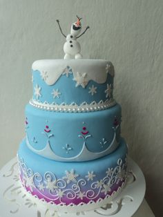 a three tiered cake decorated with frosting and snowflakes