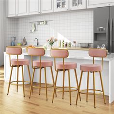 three pink bar stools in front of a kitchen island