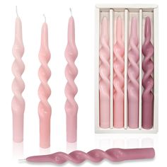 pink candles are lined up in a box and next to them is an assortment of different sizes