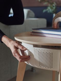 a person holding an egg near a table with a book on it and a chair in the background