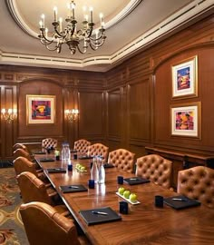 a conference room set up for a meeting with leather chairs and wooden paneled walls