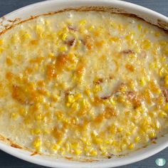 a white bowl filled with corn on top of a blue and yellow striped table cloth