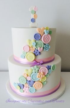 a three tiered cake with buttons on it