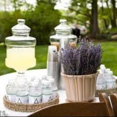 an outdoor table with bottles and lavenders on it