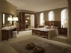 a large bedroom with an ornate bed, dresser and mirror in the middle of it