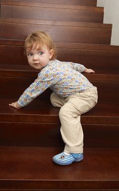 a little boy standing on top of some stairs