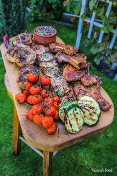 a wooden table topped with different types of meat and veggies on top of it