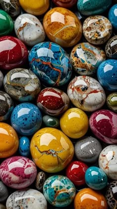 many different colored marbles are stacked on top of each other in this image, there is