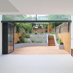 an open living room with stairs leading up to the top floor and wooden steps on either side