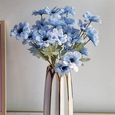 a vase with blue flowers in it sitting on a table