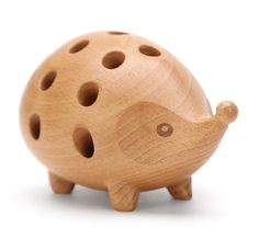 a wooden toy with holes on it's face and an animal shaped object in the middle