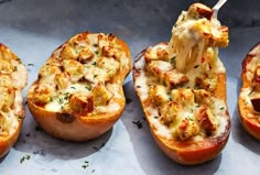 three baked stuffed peppers with cheese being lifted from the top one is filled with meat and vegetables