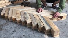 a man kneeling down next to wooden planks on the ground with his hands on them