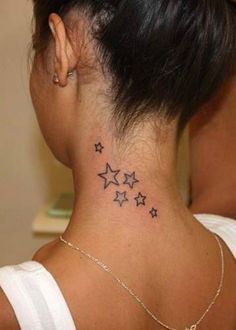 the back of a woman's neck with small stars on her left side tattoo