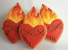 three heart shaped cookies with flames on them