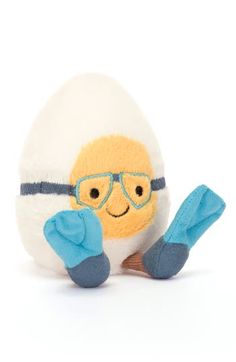 a stuffed animal with glasses and mittens on it's feet sitting next to an egg