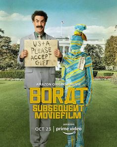 a man holding a sign in front of a poster for the movie borata