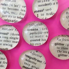 six glass magnets with words on them sitting next to each other in front of a pink background