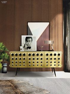 a gold sideboard with black and white photos on it