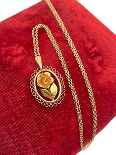 Description: Vintage necklace by Krementz.  Adorable necklace with lots of detail. This oval shaped pendant has a pink rose in the center with two leaves below. The outside of the oval has a filigree design. It is attached to a fine chain to make a lovely piece of vintage jewelry. Necklace has a fine link 18'' gold filled chain.  Dainty and feminine, as is the pendant. Unique and classic feminine locket is circa 1960s/1970s. Measurements: Necklace: 1'' long by 5/8'' wide 18'' chain Approximate W Vintage Diamond Necklace, 1970s Jewelry, Vintage Jewelry Necklace, Classic Feminine, Gold Overlay, Rose Necklace, Necklace Green, Filigree Design, Green Necklace