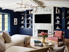 a living room filled with furniture and a flat screen tv mounted on the wall above a fireplace