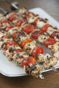 chicken and tomato kabobs on a white plate