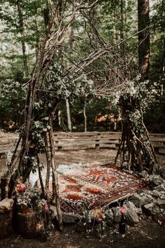 an outdoor area with a blanket and flowers on the ground in front of some trees