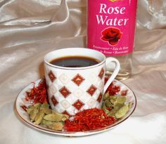 a cup of tea next to a bottle of rose water