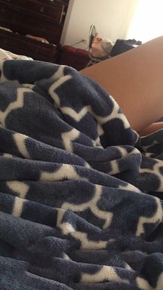 a person laying in bed under a blanket