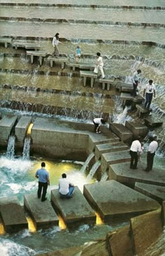 several people are standing on concrete steps in the water