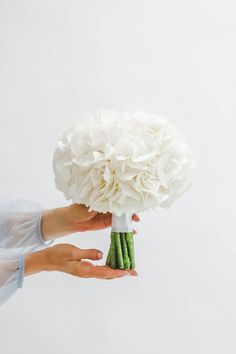 a person holding a bouquet of white flowers