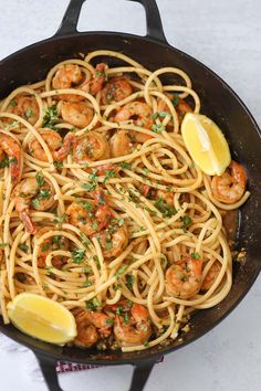 pasta with shrimp and parsley in a cast iron skillet on a white surface