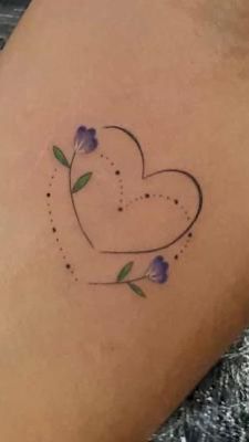 a small heart tattoo with flowers on the back of the leg, and dots in the shape of hearts