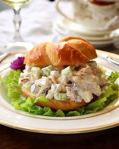 a chicken salad sandwich on a croissant with lettuce