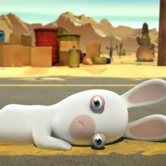 a white rabbit laying on its back in the middle of a road with boxes behind it